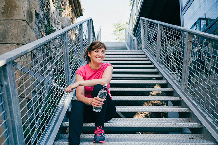 A woman outside sitting on steps