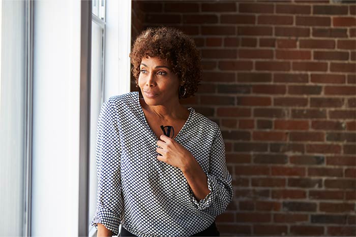 A mature woman gazing out a window